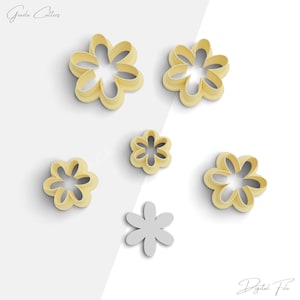 Peut inclure: Ensemble de six emportes-pièces en forme de fleur. Les emportes-pièces sont en plastique jaune clair et sont disposés sur un fond blanc. Les emportes-pièces sont de différentes tailles.
