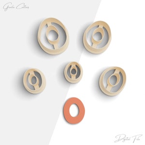 Puede incluir: Conjunto de seis cortadores de galletas en forma de donut con un agujero en el centro. Los cortadores están hechos de plástico beige claro y están dispuestos sobre un fondo blanco. Los cortadores son de diferentes tamaños. El texto "Archivo digital" está en la esquina inferior derecha de la imagen.