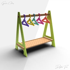 Könnte beinhalten: Ein hellgrüner Kleiderständer aus Holz mit einem hellbraunen Regal und einer Holzstange, an der fünf bunte Kleiderbügel hängen. Die Kleiderbügel sind lila, gelb, türkis, pink und rot. Der Ständer hat ein perforiertes Regal und den Text "Digital File".