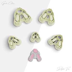 May include: A set of six cookie cutters shaped like a bunny rabbit. The cutters are made of a light beige plastic and are designed to cut out different parts of a bunny, including the head, ears, and tail. The cutters are arranged on a white background.