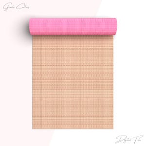 Puede incluir: Una esterilla de yoga enrollada con la parte superior rosa y la inferior beige con un patrón tejido. La esterilla está enrollada y la parte superior rosa es visible.