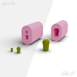 Puede incluir: Molde de silicona rosa con dos cavidades en forma de taza de café. Se muestran tres tazas de café de plástico verde en diferentes tamaños.