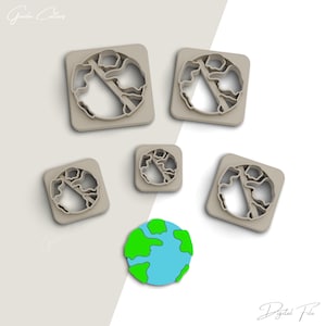 Puede incluir: Cinco cortadores de galletas con forma de la Tierra en diferentes tamaños, con una pequeña galleta de la Tierra azul y verde sobre un fondo blanco. El texto "Archivo digital" está en la parte inferior de la imagen.