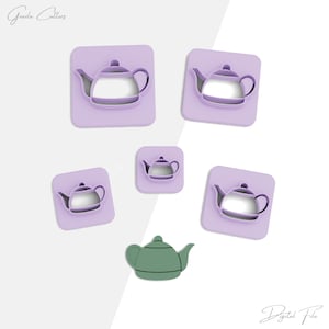 Puede incluir: Colección de cortadores de galletas con forma de tetera en varios tamaños. Los cortadores son de color lila claro y presentan un diseño de tetera. También se incluye una tetera verde. Las palabras "Grazia Cutters" y "Digital File" están escritas en cursiva.