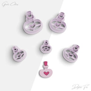 May include: Five pink plastic cookie cutters shaped like bottles with hearts. The cutters are for making cookies or fondant.