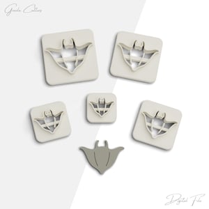 May include: Set of five cookie cutters shaped like manta rays. The cutters are white plastic and come in different sizes. The smallest cutter is grey.