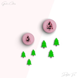 Könnte beinhalten: Ein Set mit fünf Weihnachtsbaum-Ausstechern. Zwei der Ausstecher sind rosa und haben ein detailliertes Baumdesign. Die anderen drei Ausstecher sind grün und haben ein einfaches Baumdesign mit Sternen.