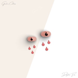 May include: Two pink silicone cookie cutters shaped like flames. There are six smaller pink flame cookie cutters scattered around the larger cutters.