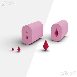 Puede incluir: Dos moldes de silicona rosa con un corte en forma de diamante. Los moldes están sobre una superficie blanca. Hay tres pequeños diamantes rojos en la superficie.