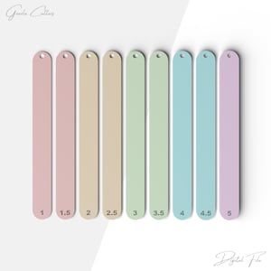 May include: Nine different colored acrylic cookie cutters in the shape of long, thin rectangles. The cutters are labeled with numbers from 1 to 5, with increments of 0.5. The cutters are arranged in a row from left to right, with the smallest cutter on the left and the largest cutter on the right.