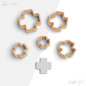 May include: Set of six cookie cutters in the shape of a cross. The cutters are made of a light brown plastic and are arranged in a staggered pattern on a white background. The cutters are different sizes, with the largest cutter being in the top left corner and the smallest cutter being in the bottom centre.