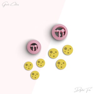 May include: Two pink cookie cutters with a design of a moon with craters. Five yellow cookie cutters with a design of a moon with craters. The text "Gazala Cutters" is in the top left corner of the image. The text "Digital File" is in the bottom right corner of the image.