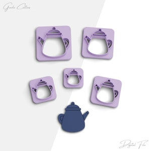 May include: Set of five purple plastic cookie cutters shaped like teapots. The cutters are in different sizes. There is also a single blue teapot cookie cutter.