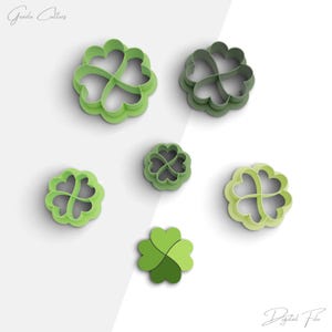 Puede incluir: Conjunto de seis cortadores de galletas de trébol de cuatro hojas de color verde. Los cortadores son de diferentes tamaños y están dispuestos sobre un fondo blanco.