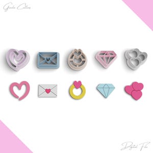 Op de afbeelding: Een set van tien koekjesvormen in verschillende vormen, waaronder harten, diamanten, enveloppen en ringen. De vormen zijn gemaakt van plastic en zijn roze, blauw en geel.