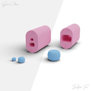 May include: A set of three pink and blue silicone molds for making candy or soap. The molds are shaped like a rectangle with a hole in the middle, and a sphere. The molds are on a white background.