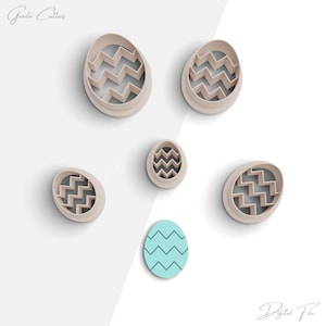May include: Set of six plastic cookie cutters in the shape of an egg with a chevron pattern. The cutters are in various sizes and are arranged on a white background.