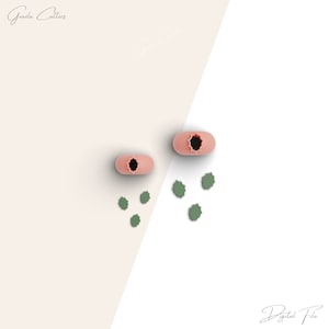 Puede incluir: Dos cortadores de galletas de silicona rosa en forma de flor con un centro en forma de estrella. Cinco cortadores de galletas de silicona verde en forma de hoja están dispersos alrededor de los cortadores de galletas en forma de flor.