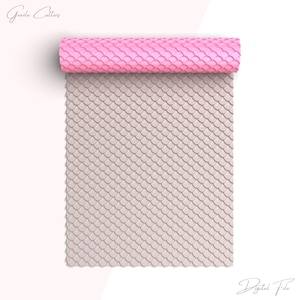 May include: A pink and white silicone rolling pin with a mermaid scale pattern. The rolling pin is rolled up and the pattern is visible on the surface.