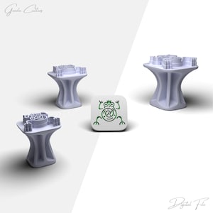 May include: Four light purple 3D-printed cookie cutters with a unique design, along with a white square with a green frog illustration. The cutters have a pedestal base and a detailed top. The image also includes the text "Greeda Cutters" and "Digital File".