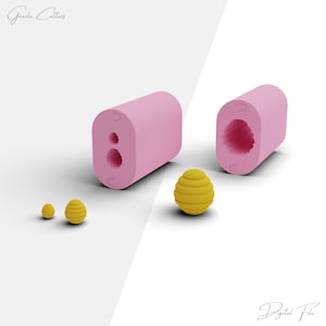 Pode incluir: Imagem de moldes rosa retangulares com formas internas, ao lado de três objetos esféricos amarelos com um design em camadas texturizado. Os textos "Grazia Cutters" e "Digital File" são visíveis.