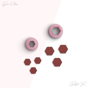 Puede incluir: Un conjunto de cortadores de galletas de color rosa y marrón. Los cortadores tienen forma de hexágonos. Los cortadores rosas son más grandes que los cortadores marrones. El texto "Archivo digital" es visible en la esquina inferior derecha de la imagen.