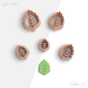 May include: Set of six leaf-shaped cookie cutters in a light brown color. The cutters are arranged on a white background. The largest cutter is at the top left of the image. The smallest cutter is at the bottom right of the image. There is a green leaf-shaped cookie cutter in the center of the image.