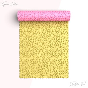 May include: A yellow silicone rolling pin with a pattern of small leaves. The rolling pin is rolled up and the pattern is visible on the surface. The rolling pin is for baking and decorating.