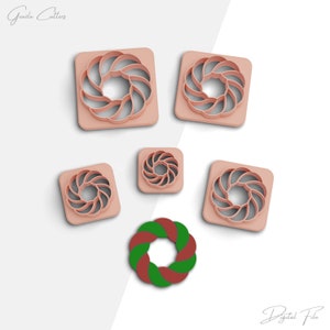 May include: Set of six pink plastic cookie cutters shaped like a wreath with a swirl design. The cutters are arranged on a white background. There is also a red and green wreath cookie cutter in the centre of the image.
