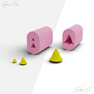 May include: Two pink silicone moulds for making small bell-shaped decorations. The moulds are shown next to three yellow bells of different sizes.