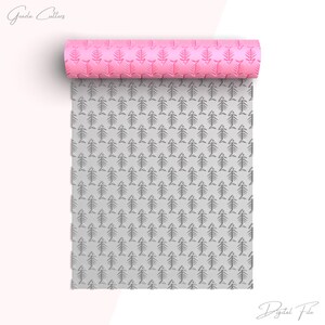 May include: A pink rolling pin with a fishbone pattern. The rolling pin is unrolled and the pattern is visible on the gray surface.