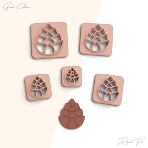 May include: Set of six pink plastic cookie cutters shaped like pine cones. The cutters are arranged on a white background. The largest cutter is in the center of the image. The smallest cutter is in the upper right corner of the image. The cutters are all the same design, but vary in size.  The word "Digital File" is written in the lower right corner of the image.