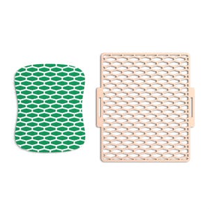 May include: Two kitchen items on a white background. A green and white sponge with a honeycomb pattern is next to a beige, rectangular trivet with a honeycomb design and handles.