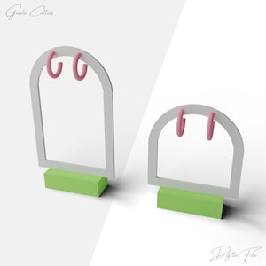 Könnte beinhalten: Zwei Ohrring-Displays mit rosa Creolen. Die Displays haben einen weißen Bogenrahmen und eine grüne rechteckige Basis. Der Text "Grazia Cutters" befindet sich in der oberen linken Ecke und "Digital File" in der unteren rechten Ecke.