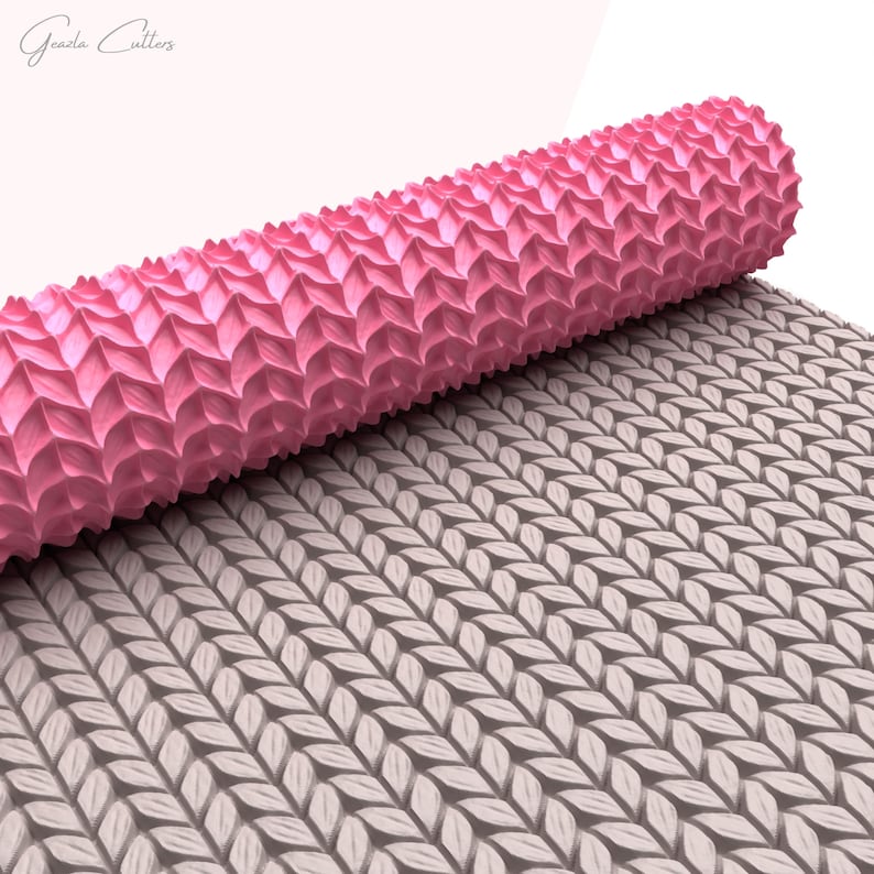 Puede incluir: Un rodillo rosa con una superficie texturizada, que se desenrolla para revelar un patr&oacute;n de hojas superpuestas. El rodillo est&aacute; dise&ntilde;ado para crear patrones decorativos en fondant o masa.