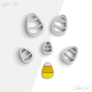 May include: Set of six candy corn cookie cutters in various sizes. The cutters are white and feature a candy corn design. A small, yellow, orange, and white candy corn is also shown.