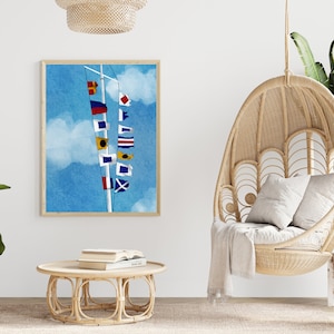 May include: A framed print of a nautical flag signal on a blue sky background. The flags are a variety of colors and patterns, including red, white, blue, yellow, and black. The print is hanging on a white wall above a wicker chair and a coffee table.