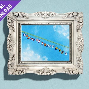 Puede incluir: Una impresión enmarcada de un cielo azul con nubes blancas y una cuerda de banderas náuticas colgando de ella.