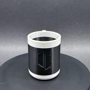 May include: A set of three ceramic mugs with a speckled, matte finish. The mugs are in shades of cream, light gray, and dark gray. Each mug has a simple, minimalist design and a rounded handle.