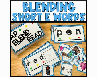 May include: A set of blue and white flashcards with the words "Blend and Read" on a blue and white container. The flashcards have short vowel words with color-coded dots to represent the sounds. The words include "pen", "fed", and "bed".