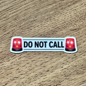 May include: A rectangular sticker with a white background and a black border. The text DO NOT CALL is printed in black capital letters in the center. On both the left and right sides of the text, there is a red emergency siren light icon.