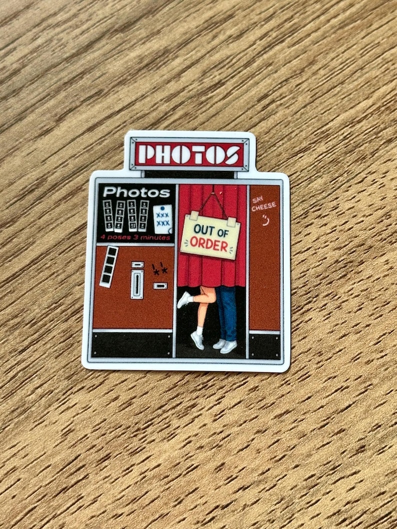 May include: A rectangular sticker depicting a vintage photo booth with a red curtain. The booth features the text "PHOTOS" at the top, "4 poses 3 minutes" on the side, and a sign hanging on the curtain that reads "OUT OF ORDER". Legs are visible.