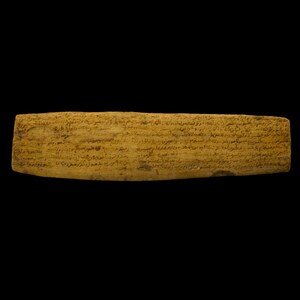 Könnte beinhalten: Eine rechteckige, hellbraune Holztafel mit eingeritztem Text. Die Tafel hat ein verwittertes Aussehen, das auf ihr Alter hindeutet. Der Text ist in einer schwer zu entziffernden Schrift. Der Hintergrund ist tiefschwarz.