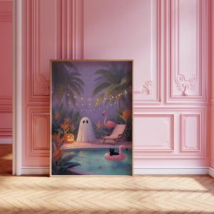 May include: A framed art print depicts a whimsical scene of a ghost, a flamingo, and a black cat in a pool. Palm trees, string lights, and a jack-o'-lantern add to the tropical Halloween theme. The artwork is set against a pink wall.