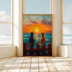 May include: Two cats sitting on a wooden fence overlooking a sunset over the ocean. The cat on the left is black and the cat on the right is orange.