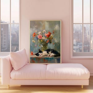 May include: A framed painting depicts a black and white cat resting near a vase of colorful flowers. The artwork is displayed on a teal surface, set against a soft, blurred background. The painting is in a gold frame, and the scene is set in a room with a pink sofa.