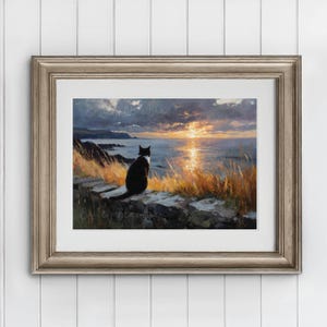 May include: A framed print of a black and white cat gazing at a sunset over the ocean. The artwork features a coastal scene with golden grasses and a stone wall. The sky is filled with clouds and the sun's reflection shimmers on the water.
