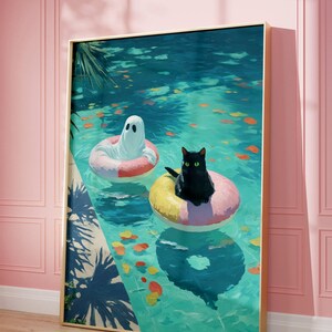 Op de afbeelding: Een ingelijste kunstdruk toont een geest en een zwarte kat die in een zwembad op opblaasbare ringen drijven. Het zwembadwater is turquoise, met kleurrijke bladeren. Het kunstwerk is ingelijst in goud.
