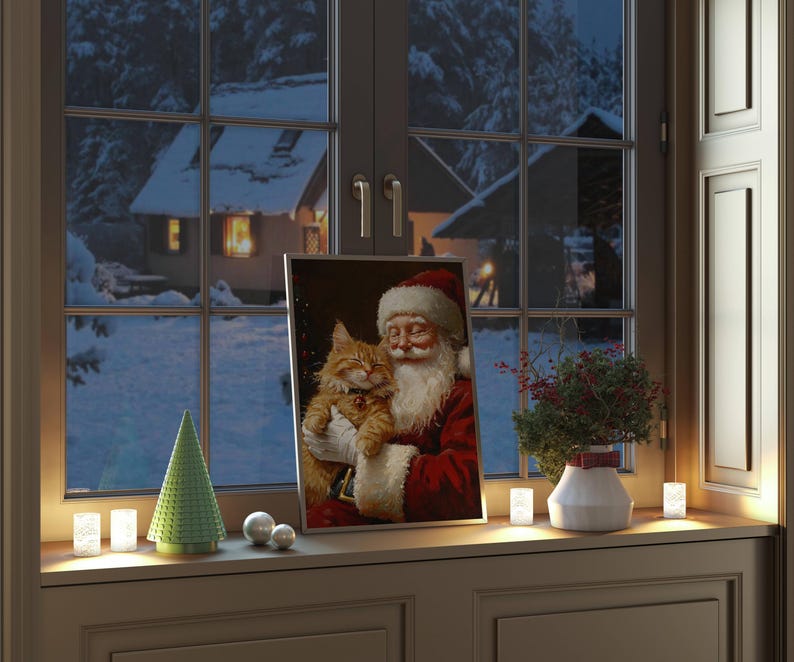 May include: A framed painting of Santa Claus holding a ginger cat. The painting is on a windowsill with a small green Christmas tree and white candles.