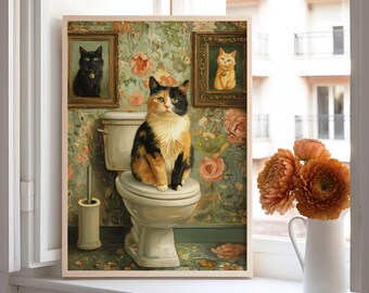 Könnte beinhalten: Ein gerahmter Kunstdruck mit einer Schildpattkatze auf einer Toilette, mit zwei gerahmten Katzenporträts darüber. Der Hintergrund hat ein florales Tapetendesign. Der Druck wird auf einer Fensterbank neben einer weißen Vase mit orangefarbenen Blumen ausgestellt.